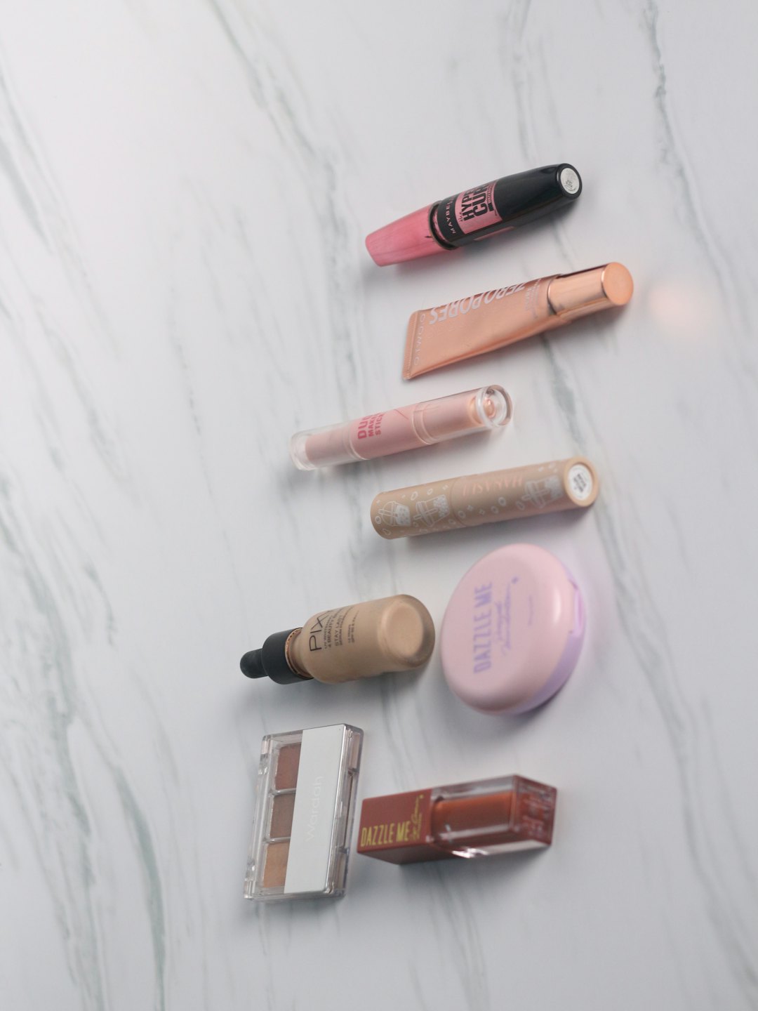Makeup products are neatly arranged on a white marble surface.